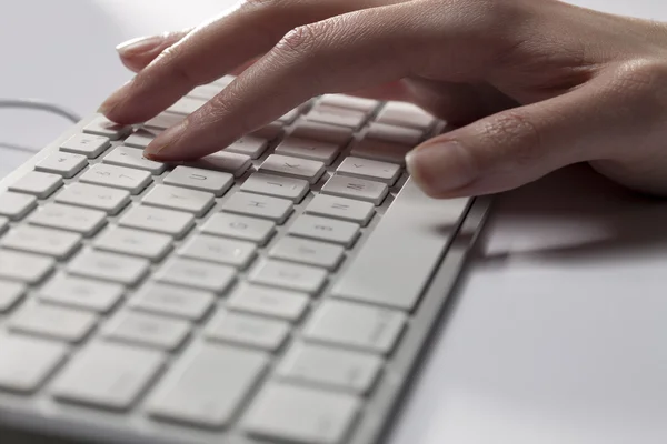 Cropped image of a human hand on computer keyboard