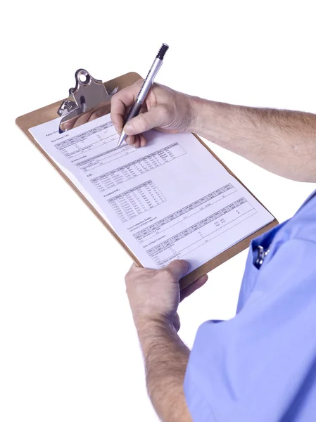 A male doctor writing on the medical clipboard