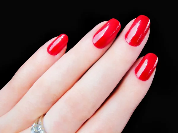 Beautiful pretty woman\'s womans hand fingers with sexy red fingernails nails isolated on black background