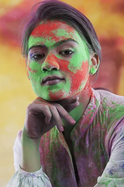 Woman\'s face covered in holi colours