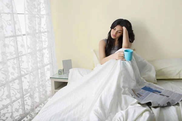 Girl having morning coffee in bed