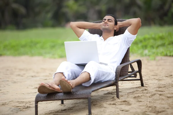 Man with a laptop at a beach
