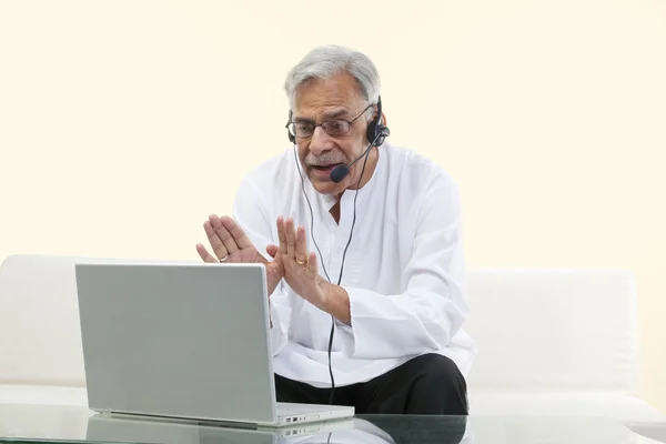 Old man with a laptop chatting online