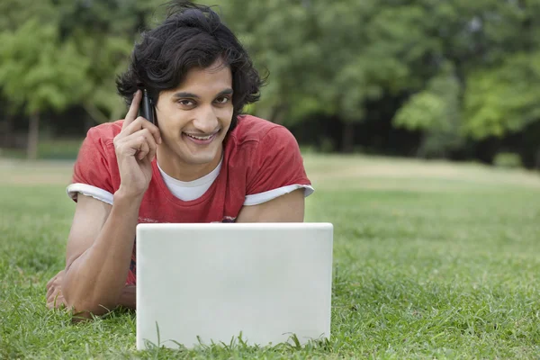 Young man reading text message with laptop