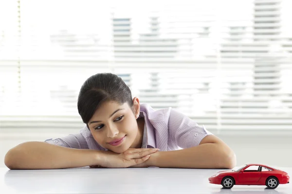 Female executive dreaming looking at car model