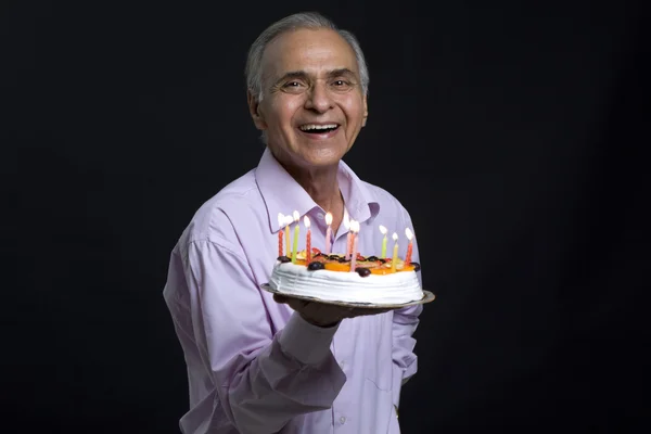 Smiling senior man looking at cake