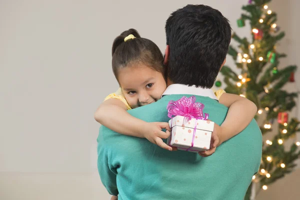Cute girl with father holding gift