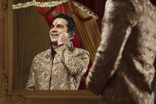 Indian groom talking on mobile phone