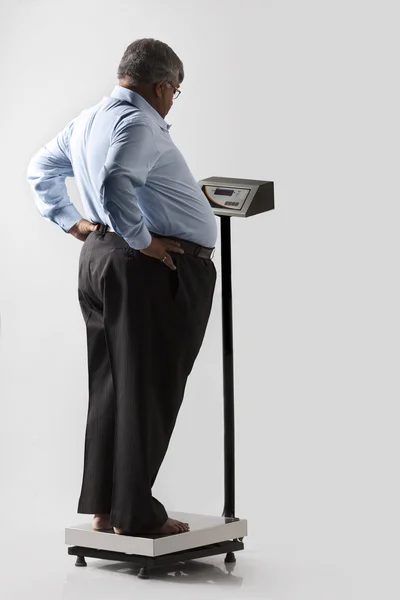 Obese man with weighing scale