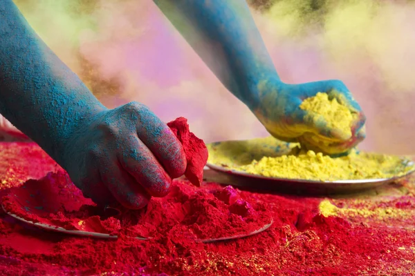 Blue colored hands holding powder paint
