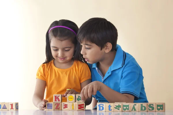 Brother and sister playing with blocks