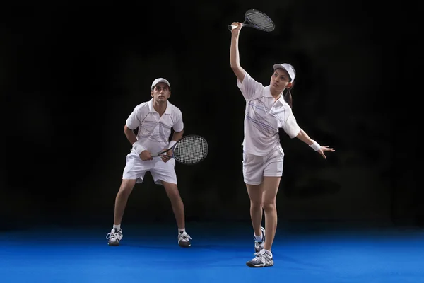 Man and woman playing tennis doubles