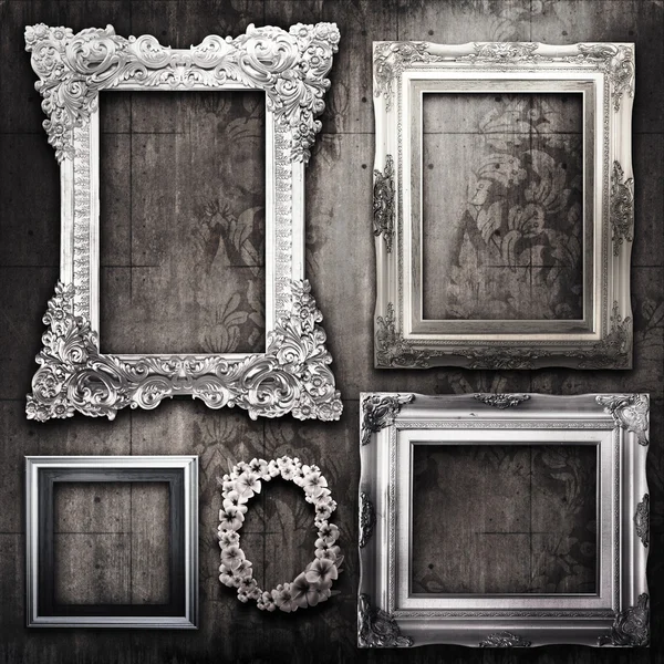 Grungy room with silver frames and Victorian wallpaper