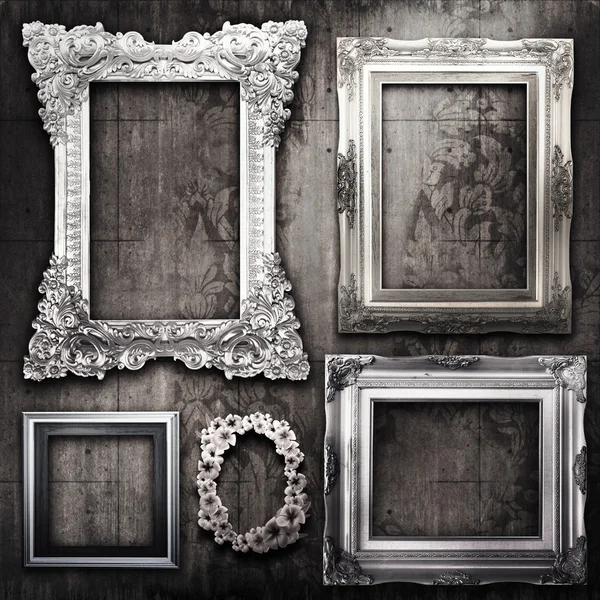 Grungy room with silver frames and Victorian wallpaper - Stock Image