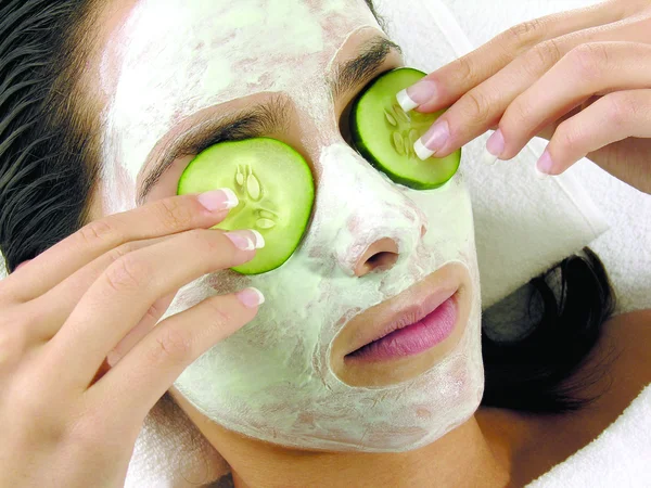 Young girl with facial mask of cucumber