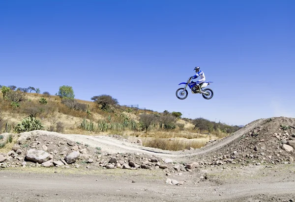 A picture of a biker making a stunt and jumps in the air