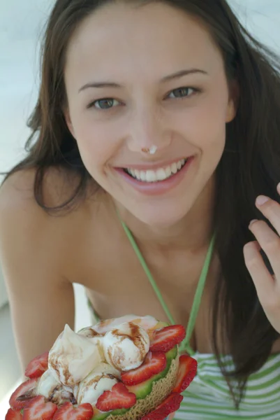 Beautiful woman enjoying fruit dessert with icecream
