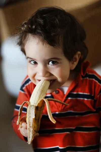 Cute little girl eating a banana