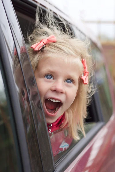 Portrait of a surprised girl in a car