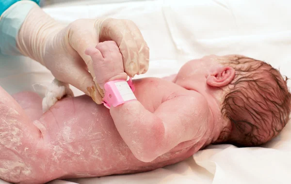 Doctor examines a newborn baby in the first few minutes of life