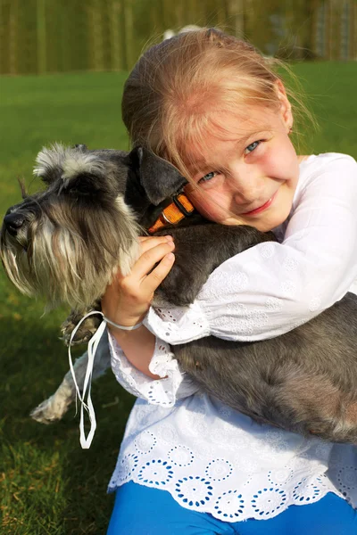 Laughing little girl hugging her dog