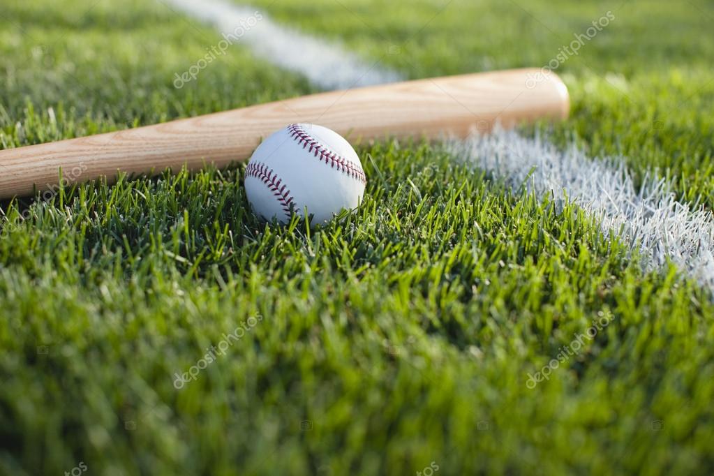 Baseball bat and ball in grass by field stripe — Stock Photo © Willard
