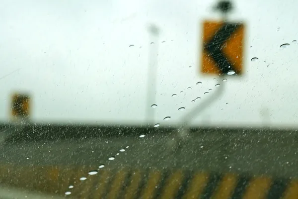 Arrow sign on street in rain (defocused)