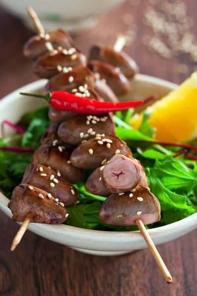 Grilled chicken hearts in spicy soy citrus marinade on skewers