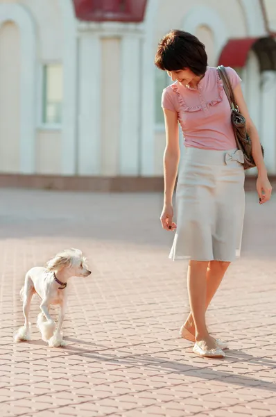 Portrait of happy female and a white dog on the street