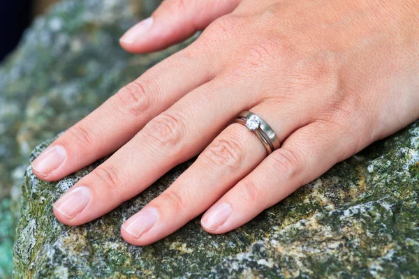 Hand with wedding and diamond engagement rings