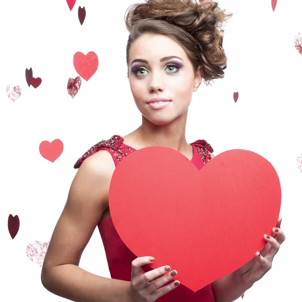 Young cheerful woman holding red paper heart