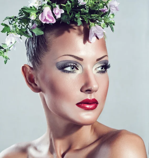 Fashion model, beautiful woman with flowers on her head, glamour makeup