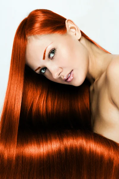 Beautiful young red-headed woman with long shiny hair