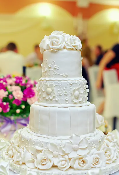 White floral wedding cake on restaurant interior background