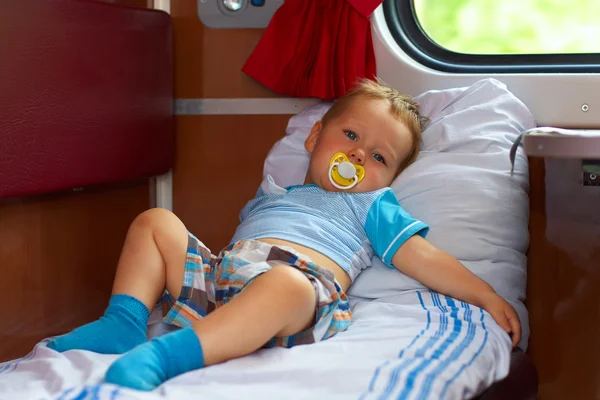 Little baby boy passenger traveling by train in sleeper car