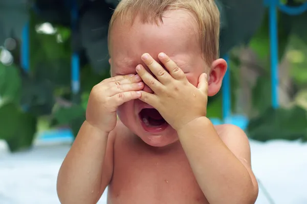 Close-up of upset little baby boy crying outdoors