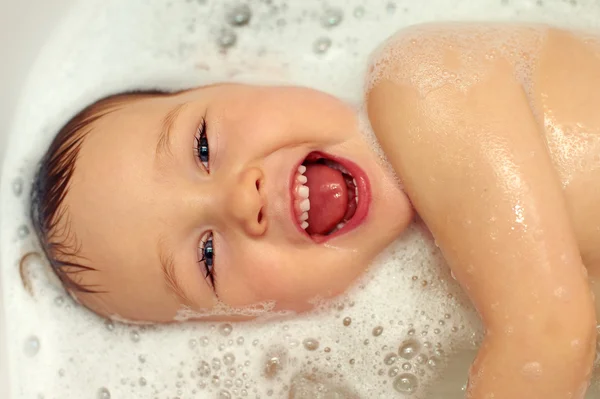 Happy baby face in bubble bath