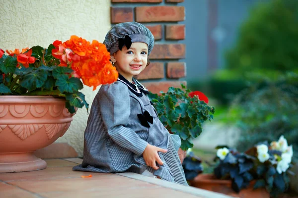 Cute little baby girl sitting on house porch steps