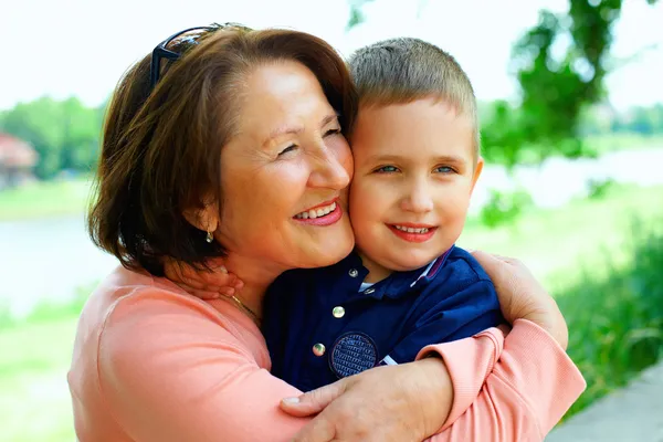 Happy grandmother with grandson having fun outside