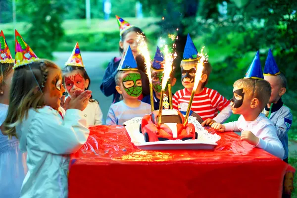 Happy kids around birthday cake