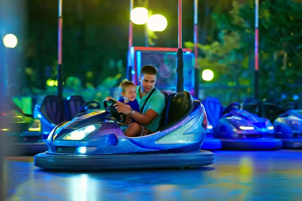 Father and son having fun, driving electric toy car