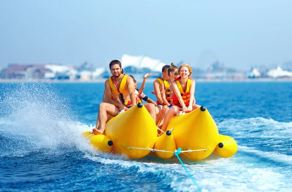 Happy people having fun on banana boat