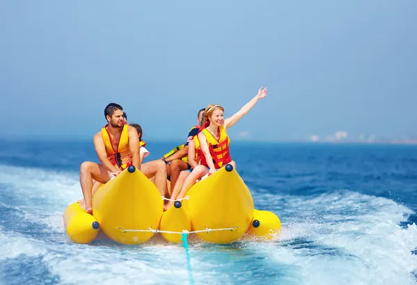 Happy people having fun on banana boat