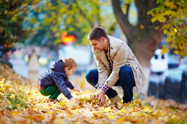 Happy father and son having fun in autumn park