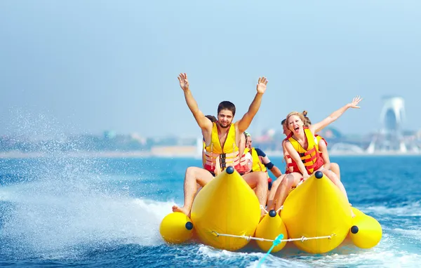 Happy people having fun on banana boat
