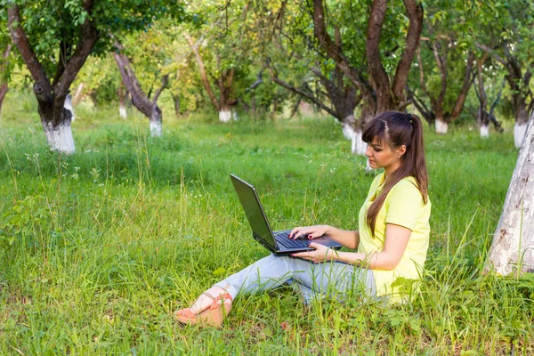 Girl with a laptop in the garden