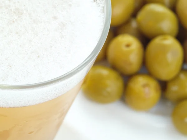 Appetizer with green olives and beer.
