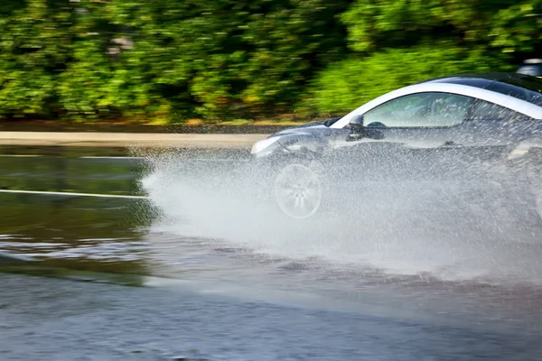 Car moving through puddle