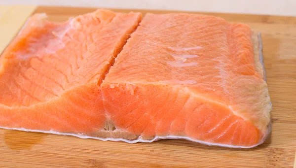 Salmon fillet on wooden background .