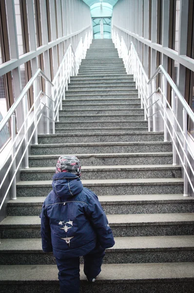 Boy makes the first steps up stairs